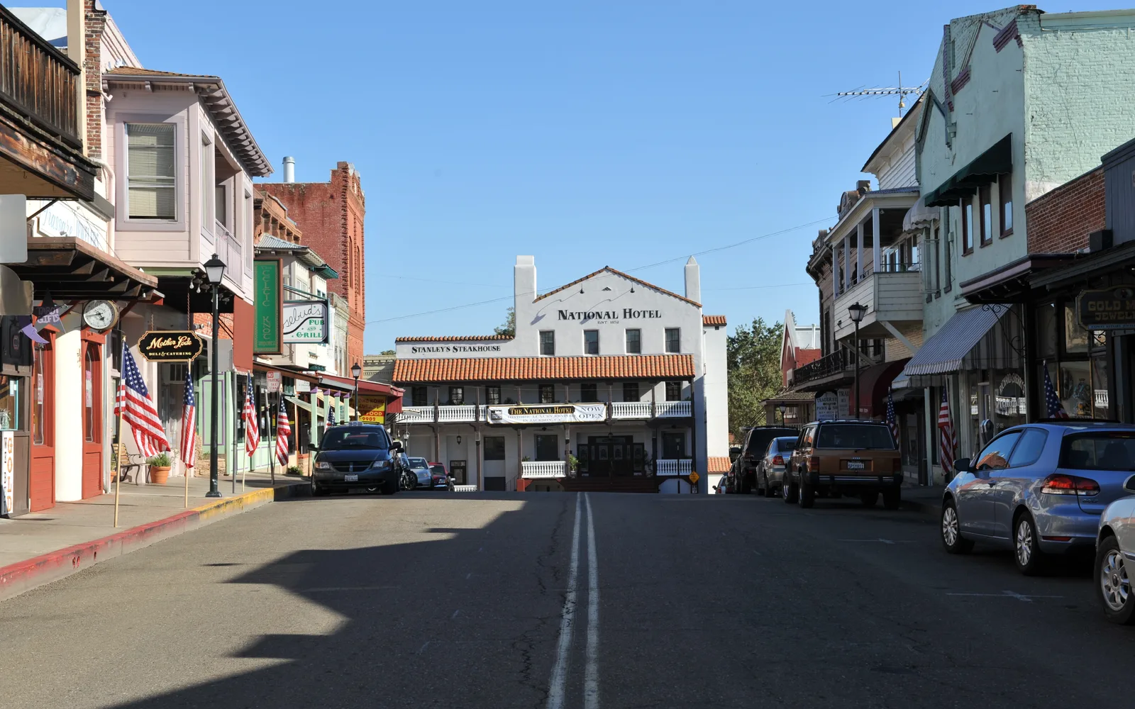 Historic Main Street with period storefronts and Victorian-era buildings, showing classic American small-town downtown architecture